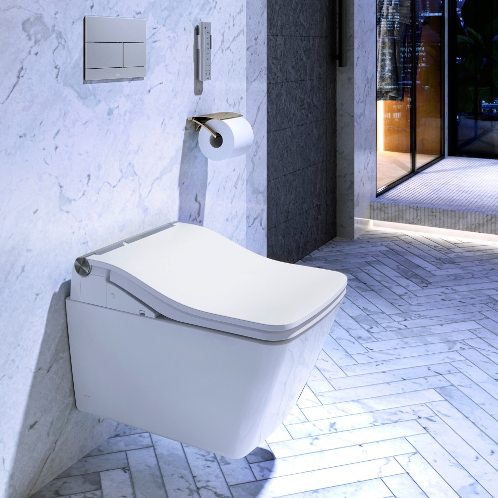 Close up lifestyle image of the TOTO Washlet SW Auto Flush Rimless Wall Hung Toilet with stainless steel dual flush plate above